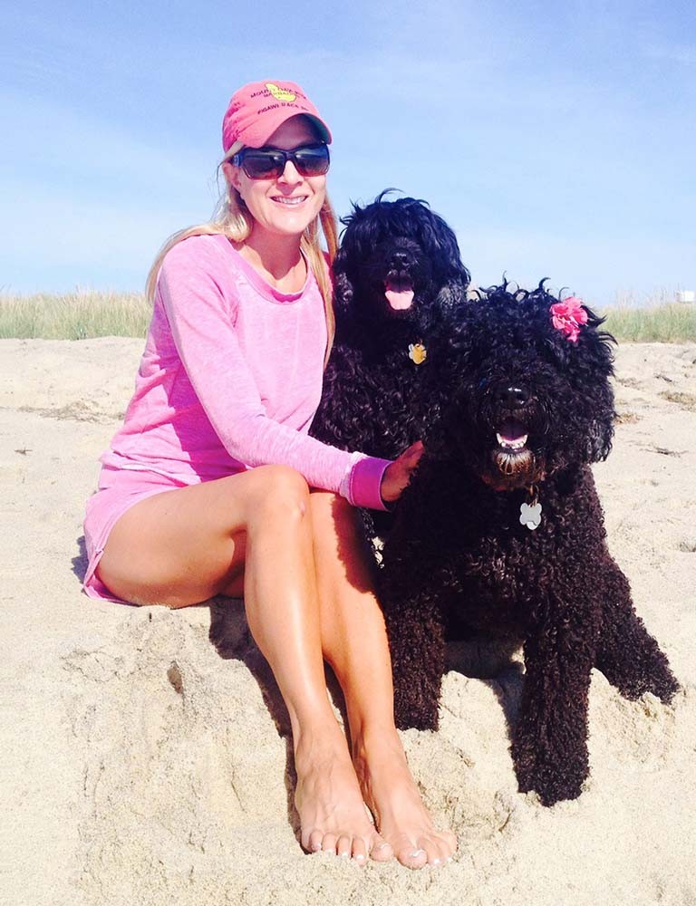Marci sedi na plaži s svojima črnima psoma